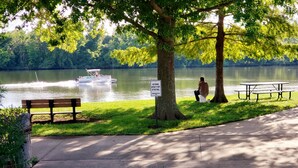 A lakeside park with a bench, picnic table, and a sign prohibiting fishing within 15 feet of the trail. - Cozy Home w/ Doggy Fence (Warsaw)