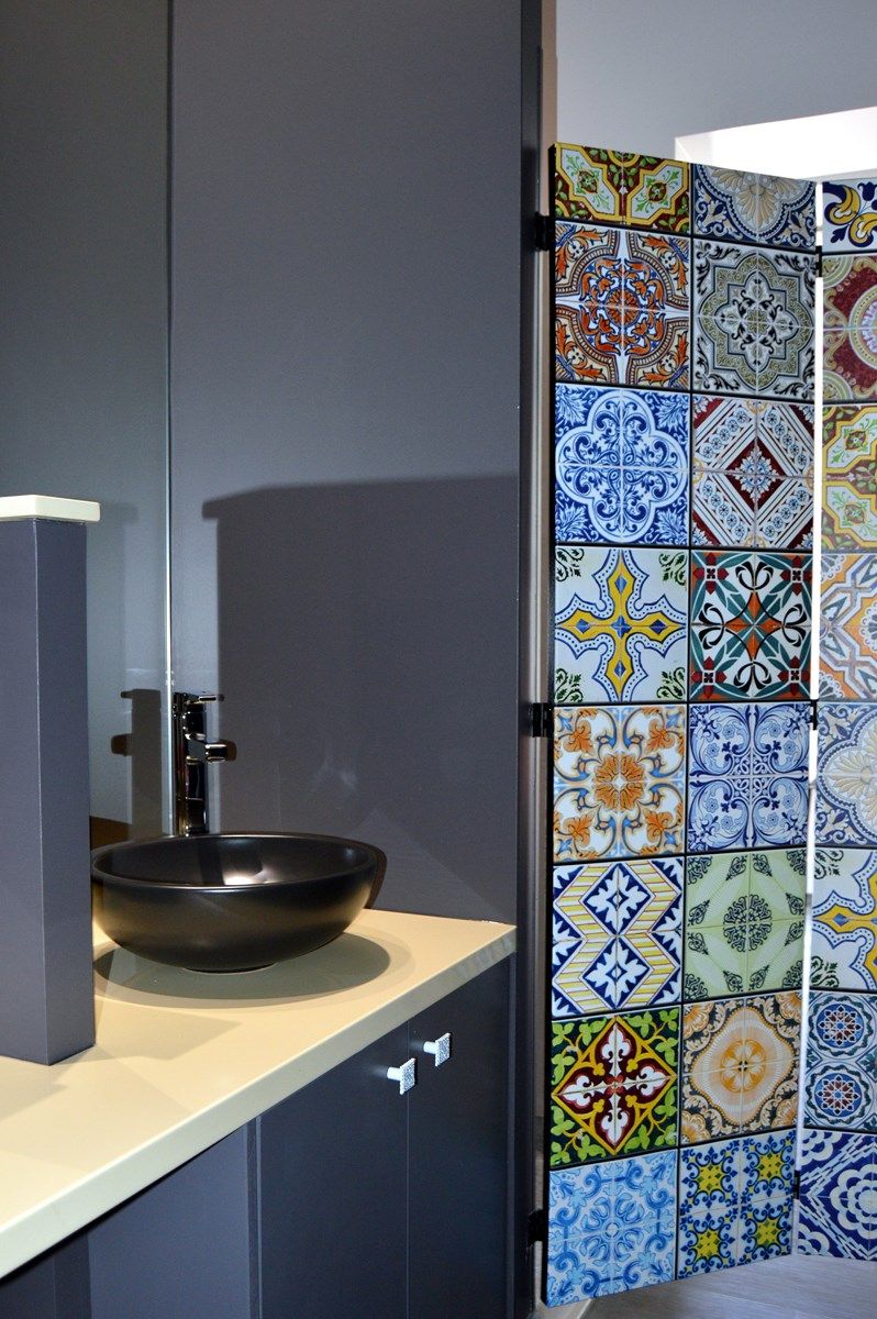 Un baño con un lavamanos moderno y una pared con azulejos.