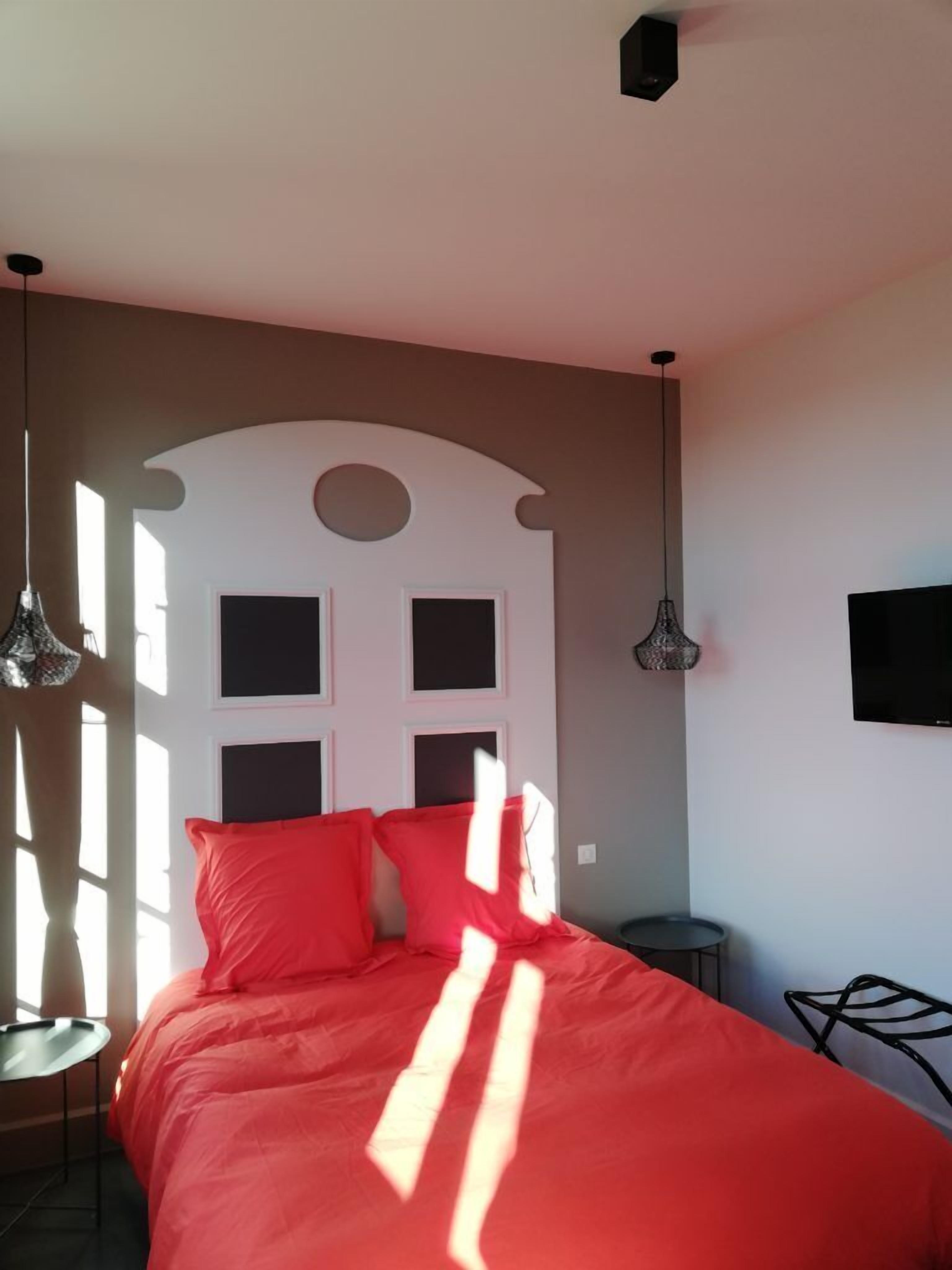 Une chambre à coucher avec un lit, une télévision et une chaise.