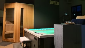 Une pièce avec un meuble en bois, un banc, une table de massage dotée de lumières vertes, et une pancarte sur laquelle on peut lire « COTE GREEN ».