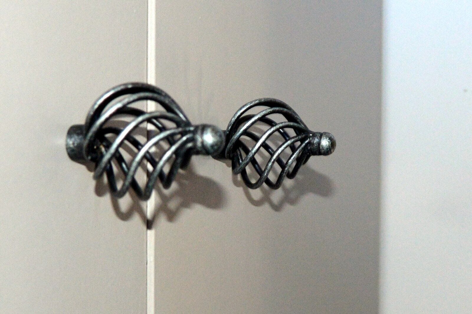 Een close-up van een metalen, spiraalvormig deurklink.