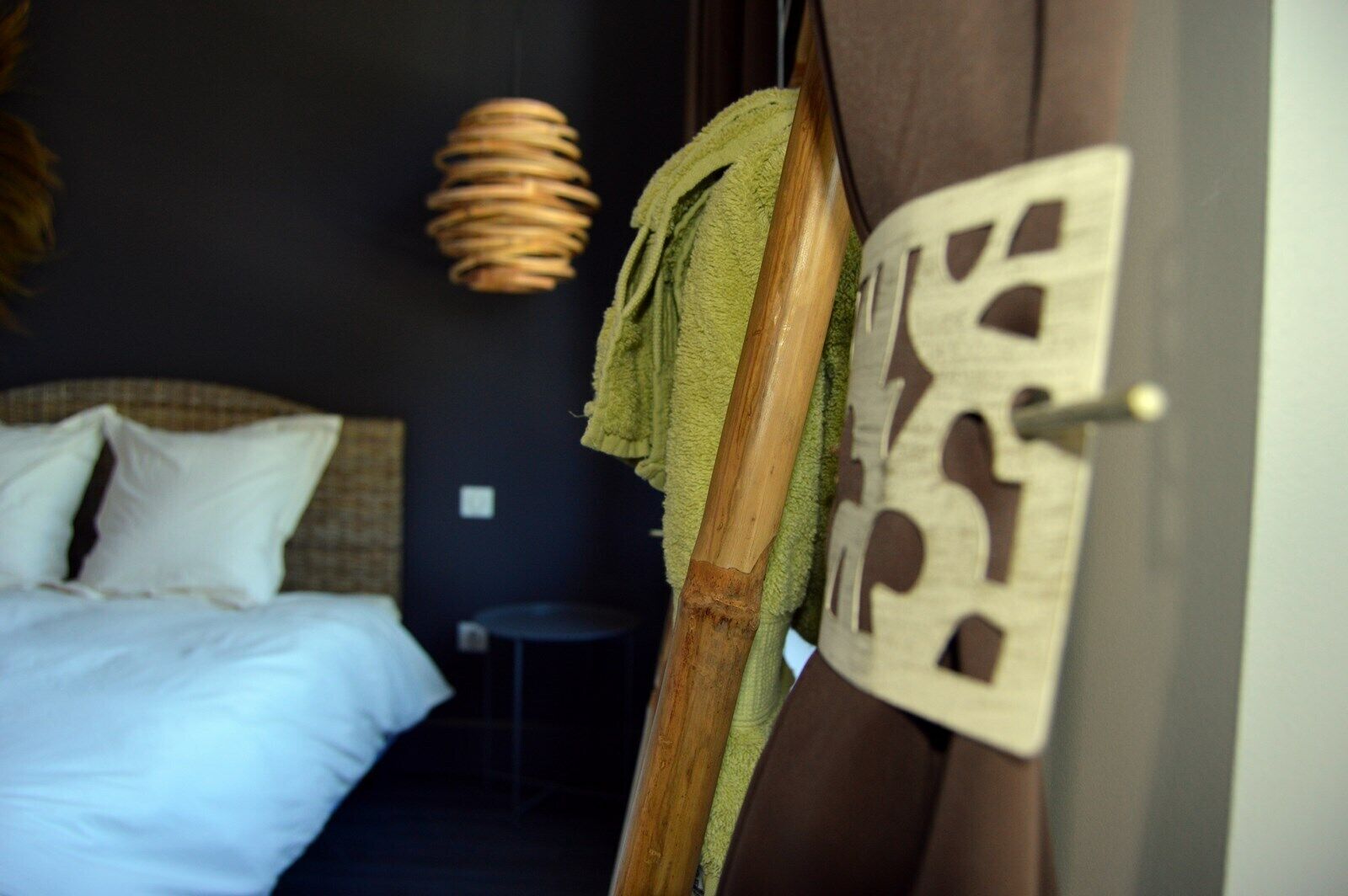 Un dormitorio con cama, lámpara colgante y una puerta con diseño decorativo.