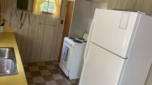 Uma cozinha compacta com fogão, geladeira e pia.