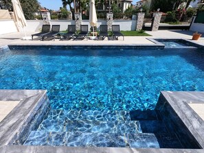 A swimming pool with clear blue water, surrounded by lounge chairs and umbrellas. - LUXURIOUS BEAUTIFUL 4 BEDROOM PRIVATE POOL VILLA IN DALYAN GULPINAR BEST AREA!! (Dalyan)