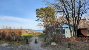 Un chemin de terre mène à un petit bâtiment sur lequel est apposée une enseigne indiquant « Service de restauration pour événements ».