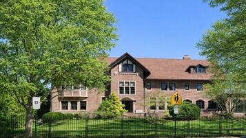 A two-story building with a brick facade, a visible entrance, and a pedestrian crossing sign.