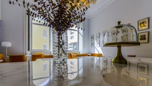 Et moderne spiseområde med et skinnende marmorbord, en dekorativ vase og en lampe betrukket med messing.