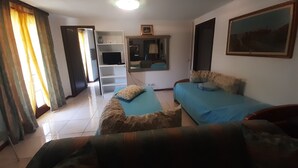 Een hotelkamer met een bed, een bank, een televisie en een spiegel.