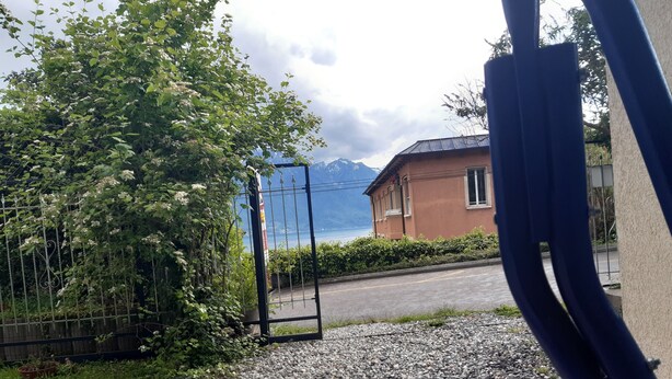 Een grindpad dat leidt naar een huis met uitzicht op een berg in de verte.