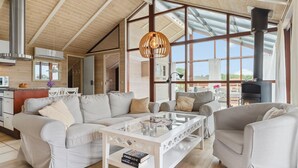 A spacious living area with a high ceiling, large windows, and a modern fireplace. - Amazing home in Sjølund with WiFi (Sjølund)