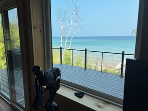 A room with a large window overlooking a beach and ocean.