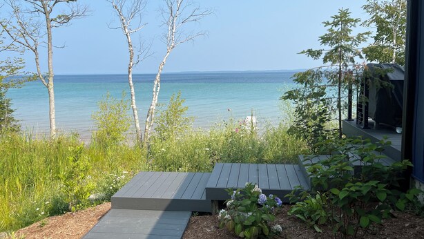 Une terrasse en bois menant à une maison avec vue sur la mer.