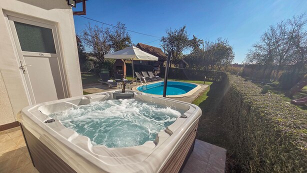 A hot tub with a view of a backyard pool and lounge chairs. - Awesome home in Gudovac (Gudovac)