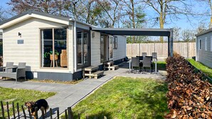 A modern mobile home with a patio area, outdoor seating, and a fenced yard. - 2 bedroom amazing home in Heinkenszand (Heinkenszand)