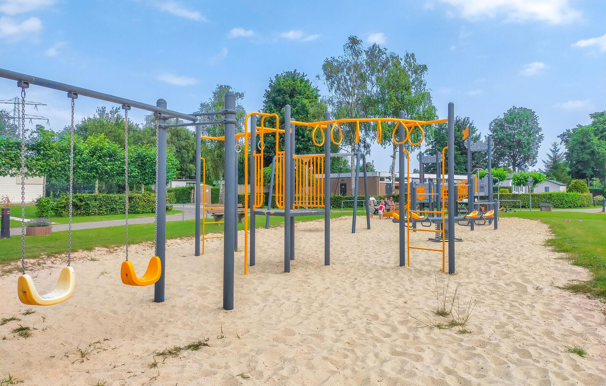 Un parque infantil con columpios y barras para escalar.