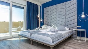 Un dormitorio moderno con una cama grande, vistas al exterior y una pared de acento azul.