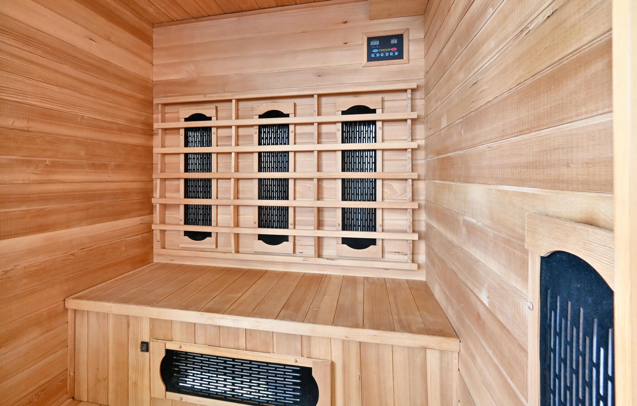 Una sauna con paredes de madera y un panel de control.