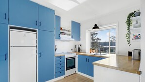 A modern kitchen with blue cabinets, a white refrigerator, a stove, and a sink. - 3 bedroom nice home in Hvide Sande (Hvide Sande)
