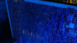 A blue-lit water feature with a mosaic tile wall. - TROPICAL PROPERTIES VACATION RENTAL - KEY WEST (Key West)