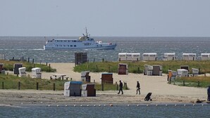 A beach with portable beach chairs and a boat in the background. - Awesome home in Büsum with sauna (Büsum)