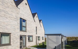 A modern building with a brick facade, large windows, and a flat roof. - Awesome home in Büsum with sauna (Büsum)