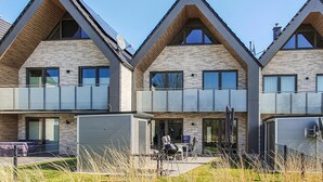 A modern residential building with a symmetrical design, featuring a central entrance with a covered patio area. - Awesome home in Büsum with sauna (Büsum)