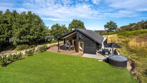 A modern house with a patio, a hot tub, and a well-maintained lawn. - Nice home in Glesborg with sauna (Glesborg)