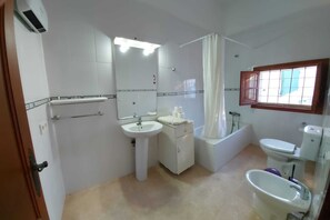 Tina con regadera, secadora de cabello, bidet, toallas 