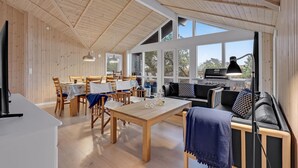 A spacious cabin with a wooden interior, large windows, a dining area, and a kitchen with a grill. - 4 bedroom stunning home in Ribe (Ribe)