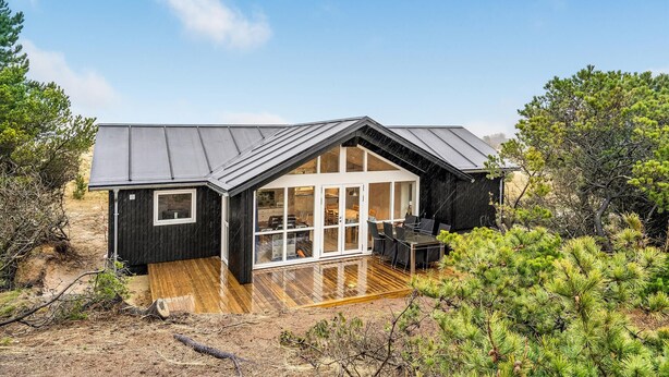 A modern cabin with a wooden deck, large windows, and a sloped roof. - 4 bedroom stunning home in Ribe (Ribe)