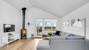 Una sala de estar moderna con chimenea, televisor y sofá.