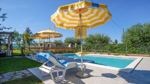 A pool area with lounge chairs and striped umbrellas. - 2 bedroom beautiful home in Corridonia (Corridonia)