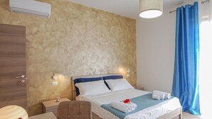 A hotel room with a bed, bedside lamps, a desk, and a chair. - 2 bedroom beautiful home in Corridonia (Corridonia)
