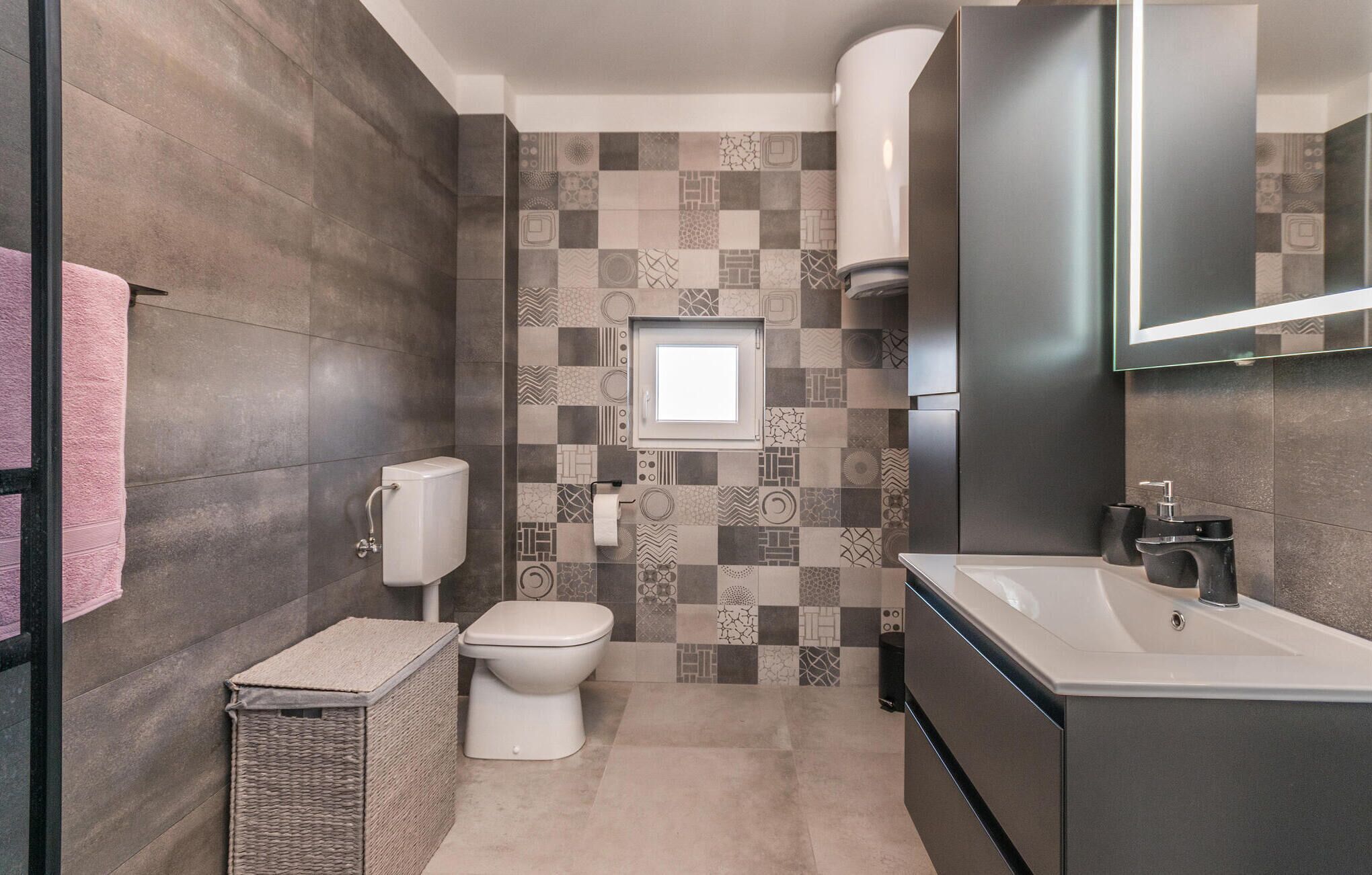 A modern bathroom with a toilet, bidet, and sink.