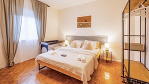 A neatly arranged bedroom with a bed, bedside lamps, a wooden floor, and a wardrobe. - Lovely home in Seline (Seline)