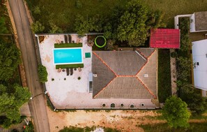 An aerial view of a property with a swimming pool, a covered patio, and a red-roofed structure. - Lovely home in Seline (Seline)