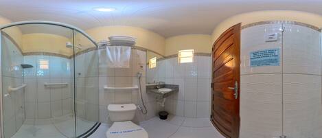 A bathroom with a glass-enclosed shower, a toilet, and a sink.