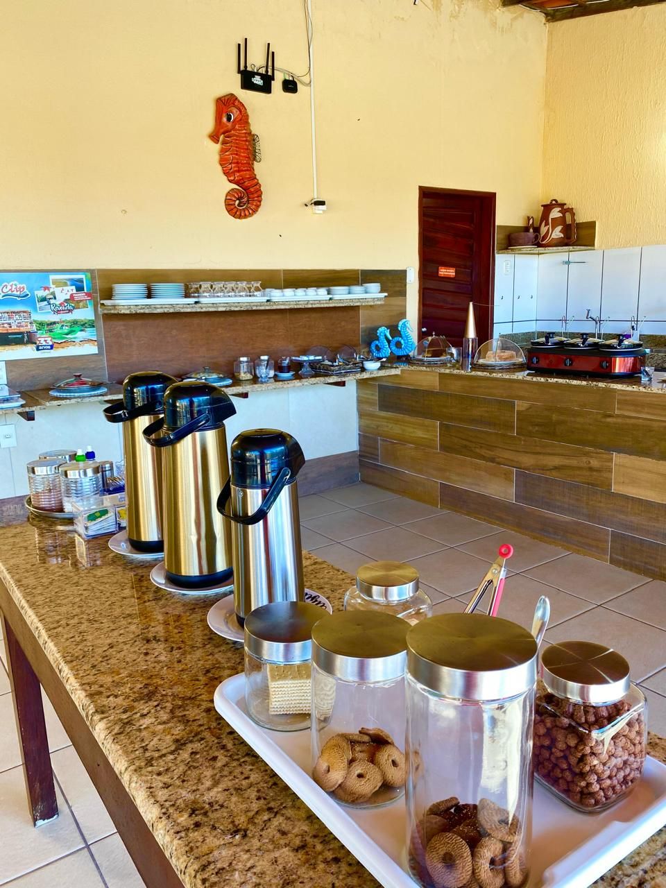 A kitchen with stainless steel appliances, a granite countertop, and various kitchenware.