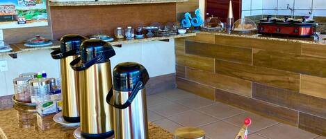 A kitchen with stainless steel appliances, a granite countertop, and various kitchenware.