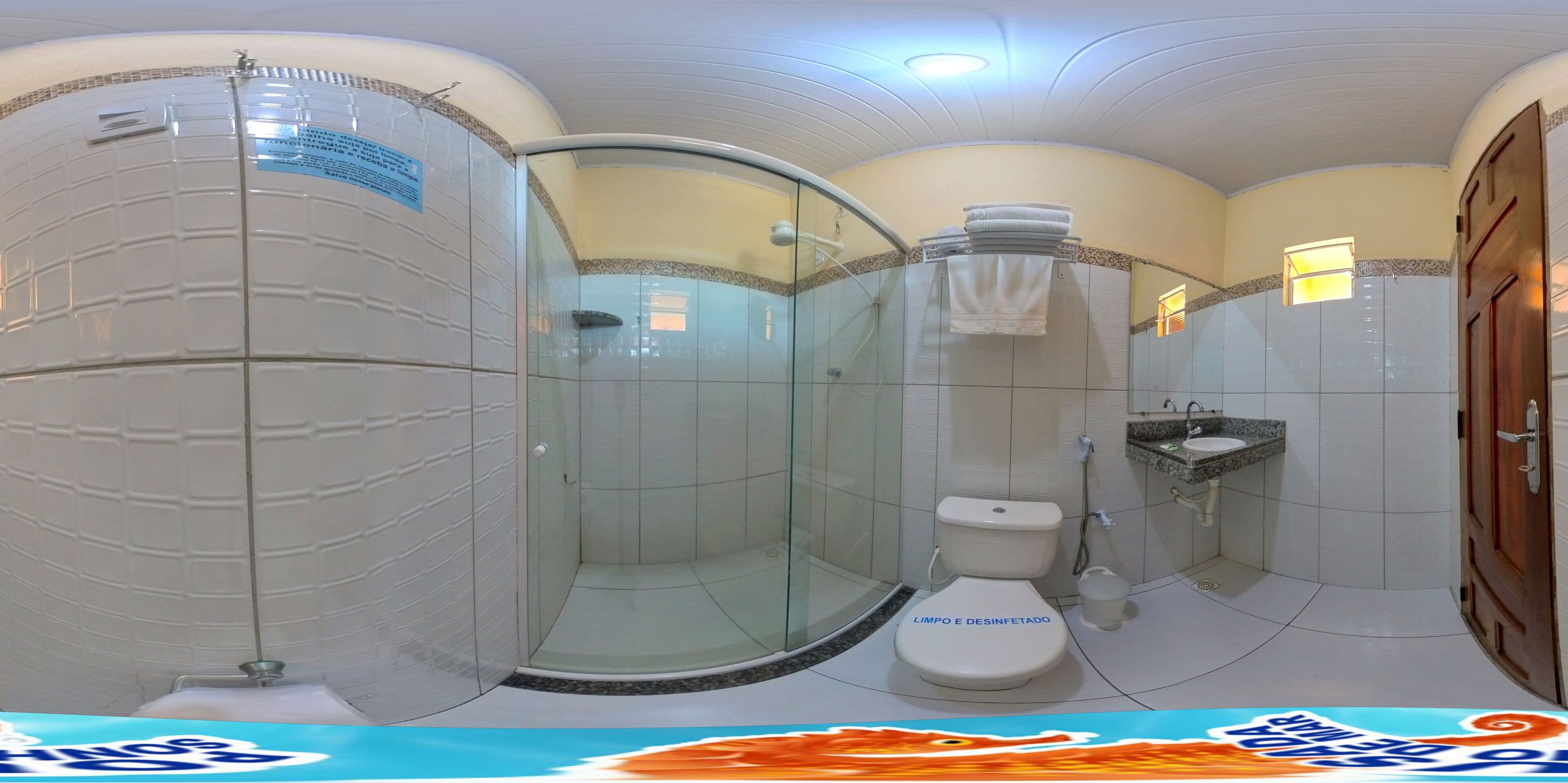 Un baño con ducha de vidrio, inodoro y lavamanos.
