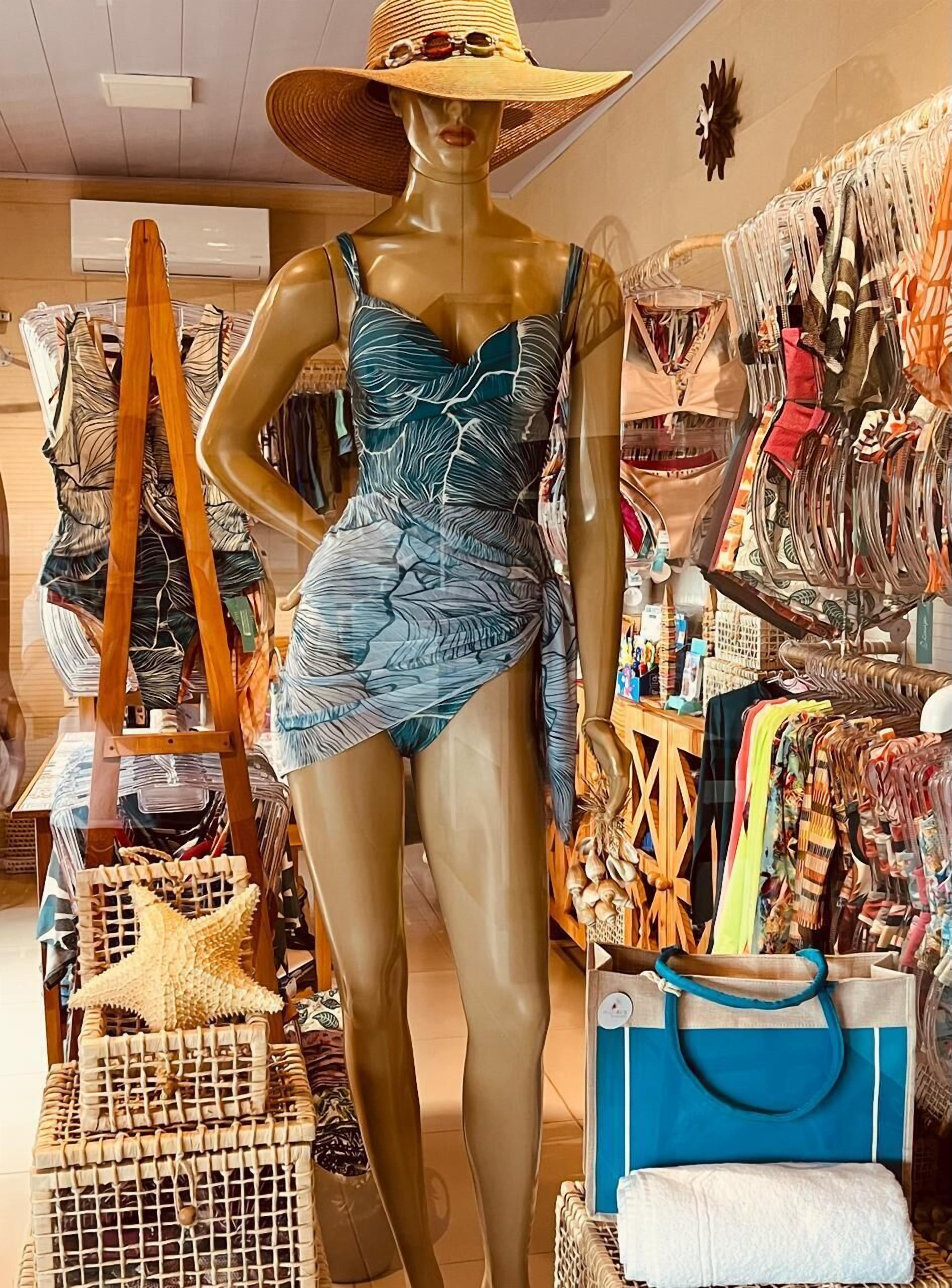 A mannequin in a boutique with various bags and accessories displayed around it.
