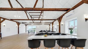 A spacious room with a long table and black chairs, wooden beams on the ceiling, and a large window with a view. - Amazing home in Grindsted with sauna (Grindsted)