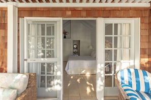 Un dormitorio con cama, mesita de noche, espejo y ventana.