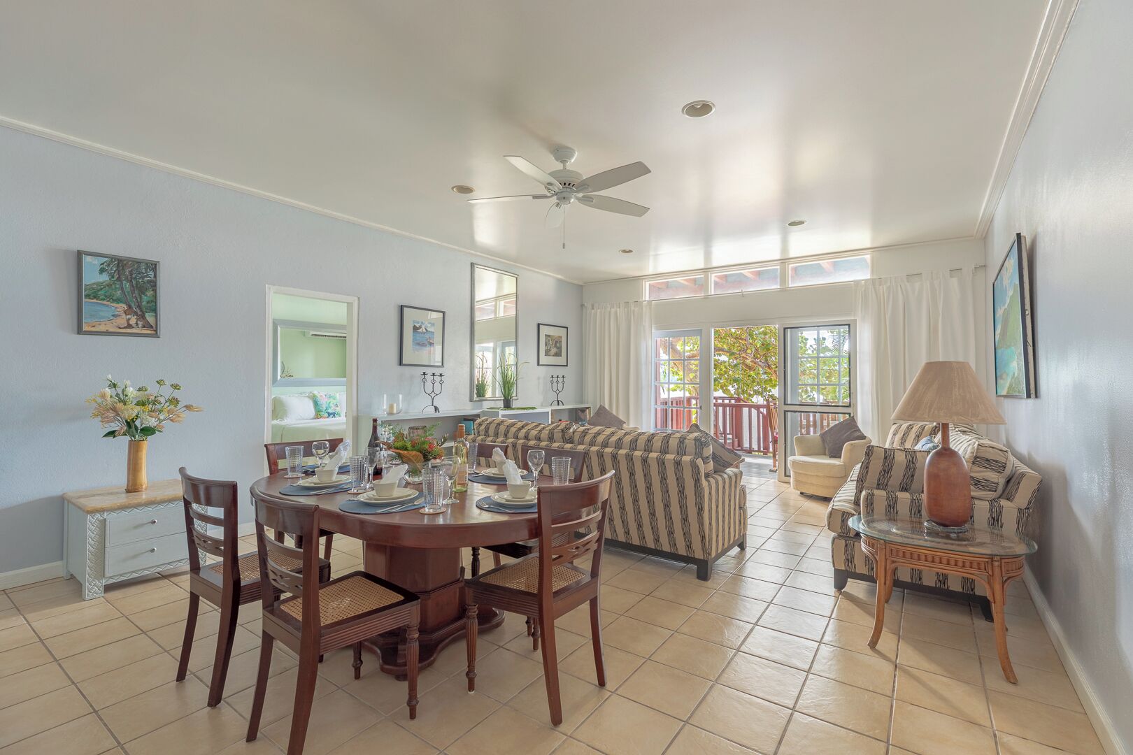 A dining area with a round table, chairs, and a ceiling fan.