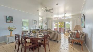 A dining area with a round table, chairs, and a ceiling fan.
