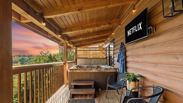 A wooden deck with a hot tub, chairs, and a sign for Netflix.