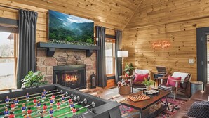 A cozy room with a fireplace, a foosball table, and a comfortable seating area.