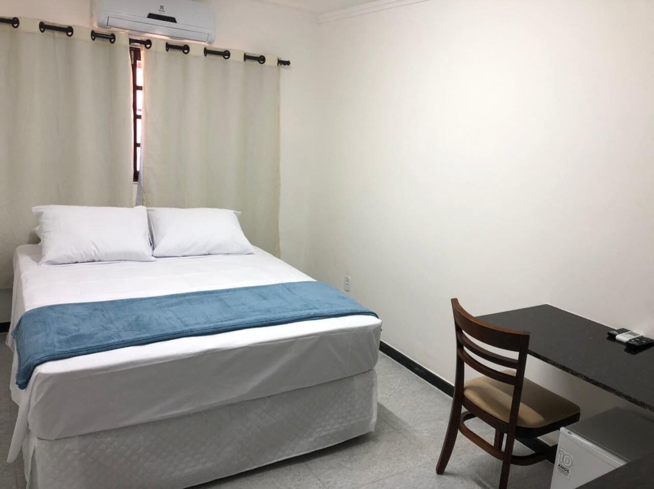 A room with a bed, a desk, and a chair.