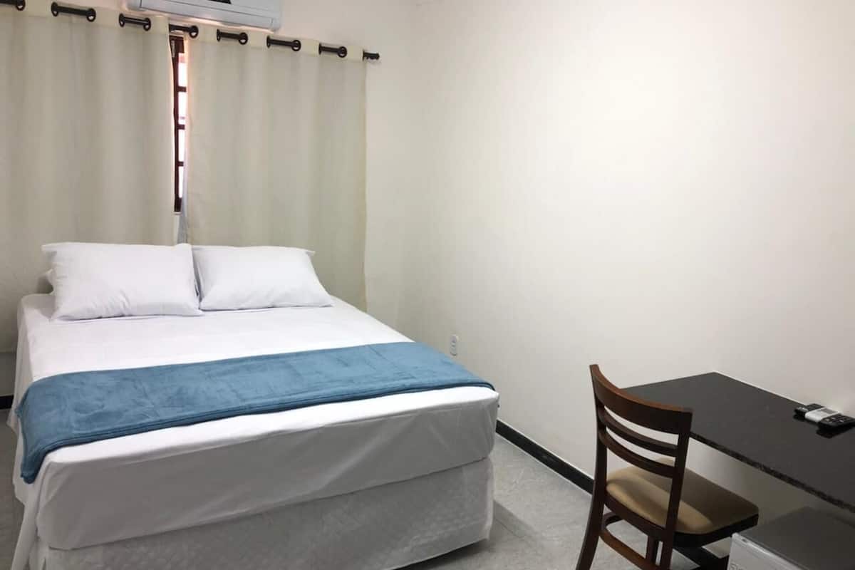 Una habitación con una cama, un escritorio y una silla.
