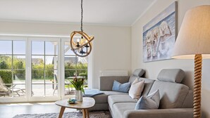 Un salon avec un canapé gris, une table basse ronde et un tableau accroché au mur.